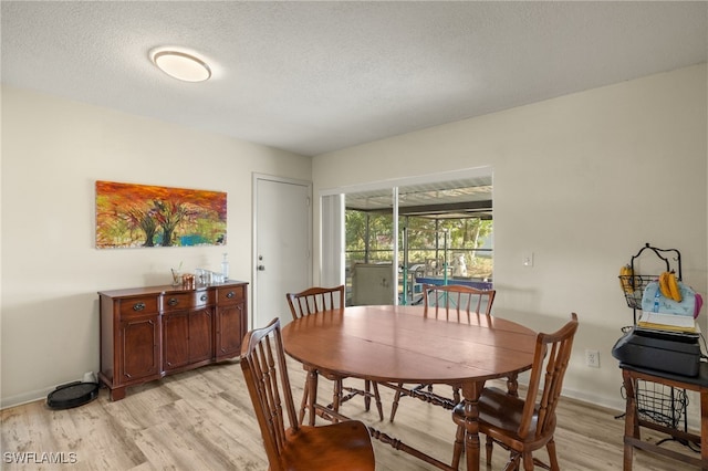 dining space featuring a textured ceiling and light wood-type flooring