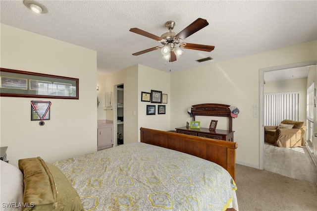 carpeted bedroom with ceiling fan and a textured ceiling