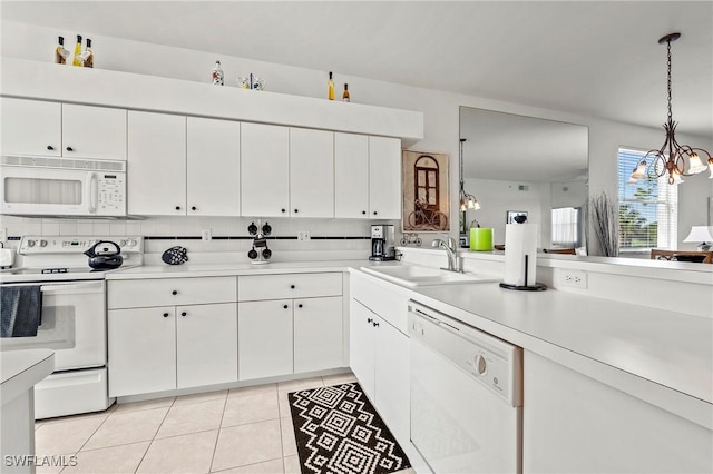 kitchen featuring sink, white cabinetry, a chandelier, pendant lighting, and white appliances