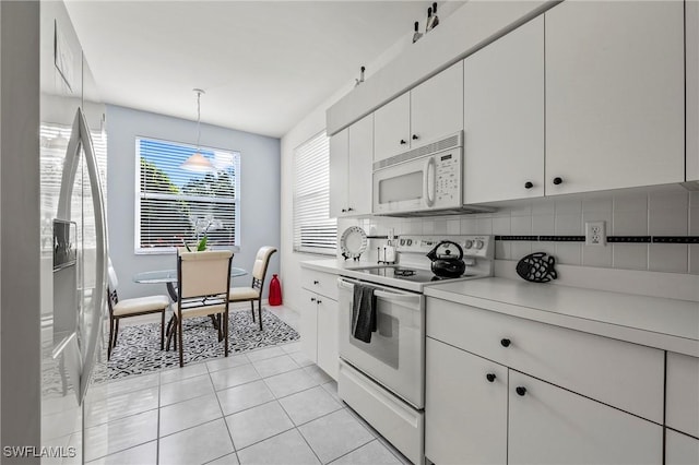 kitchen with white cabinetry, decorative backsplash, hanging light fixtures, light tile patterned floors, and white appliances