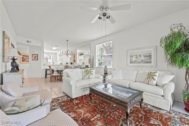 living room featuring plenty of natural light, ceiling fan with notable chandelier, and light tile patterned floors