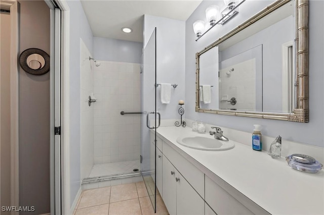 bathroom featuring tile patterned flooring, vanity, and a shower with door