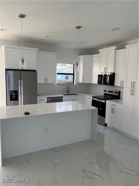 kitchen with stainless steel appliances, a sink, white cabinetry, hanging light fixtures, and light countertops