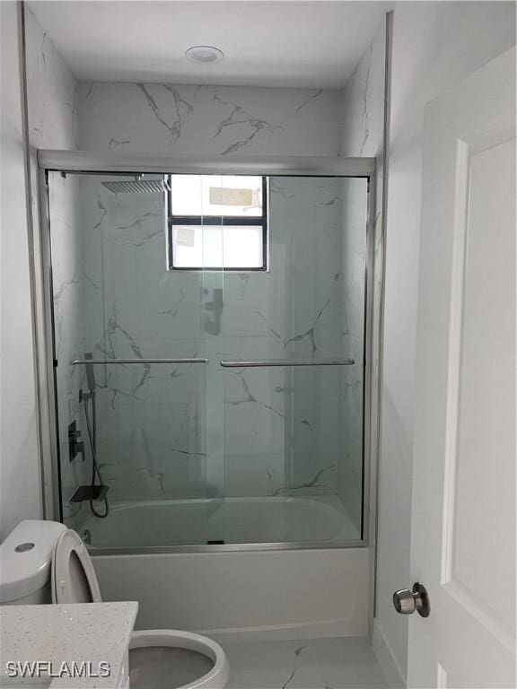 bathroom with toilet, marble finish floor, combined bath / shower with glass door, and vanity