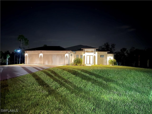 view of front of house with a garage and a lawn