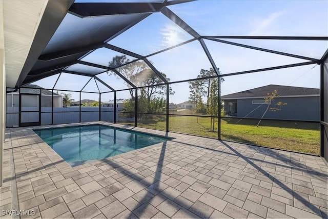 view of swimming pool with a patio, a yard, and glass enclosure