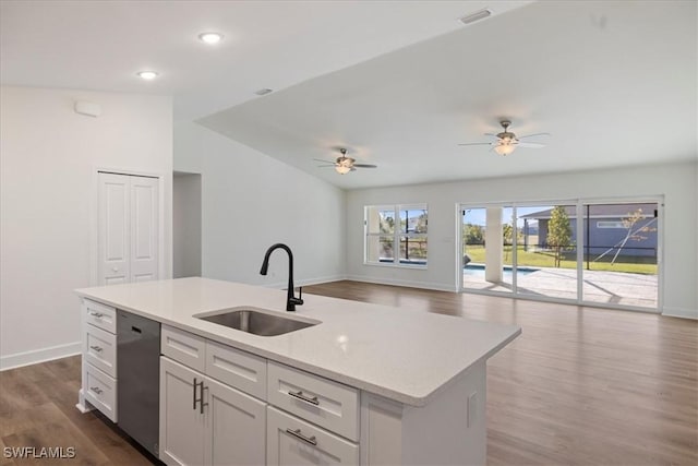 kitchen with sink, white cabinetry, wood-type flooring, stainless steel dishwasher, and an island with sink