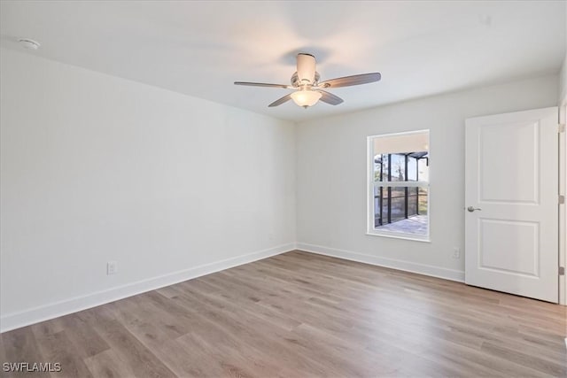 empty room with ceiling fan and light hardwood / wood-style flooring