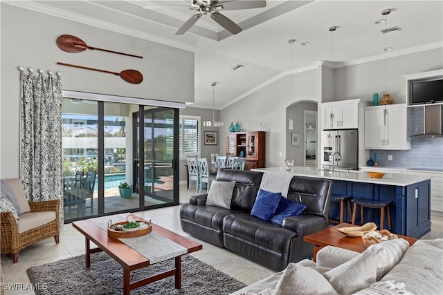 living room featuring ornamental molding, sink, ceiling fan, and high vaulted ceiling