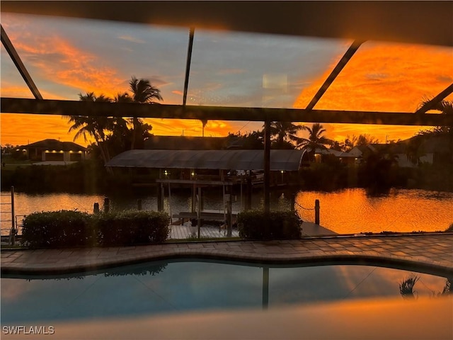 pool at dusk featuring a water view