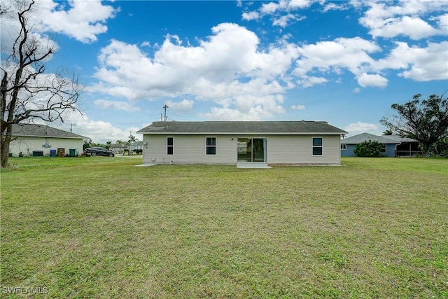 rear view of property featuring a lawn