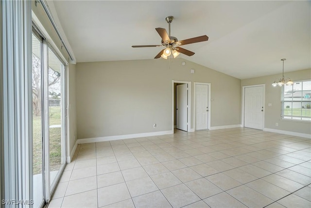 empty room with lofted ceiling, ceiling fan with notable chandelier, and light tile patterned floors