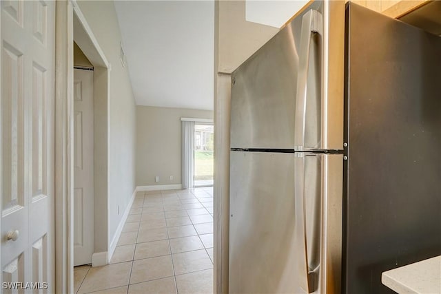 kitchen with light tile patterned floors and stainless steel fridge