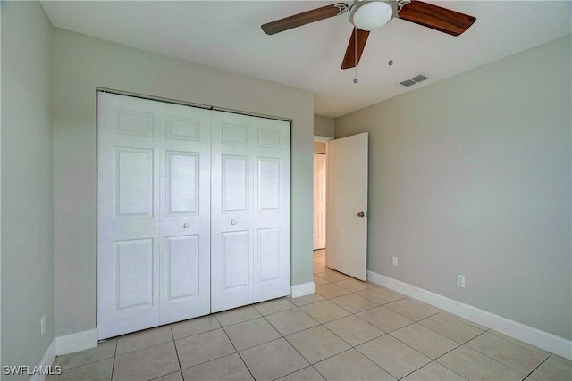 unfurnished bedroom featuring light tile patterned flooring, ceiling fan, and a closet