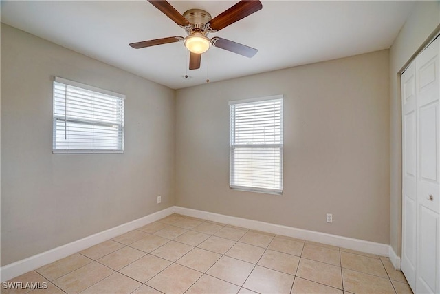 spare room featuring light tile patterned floors, plenty of natural light, and ceiling fan