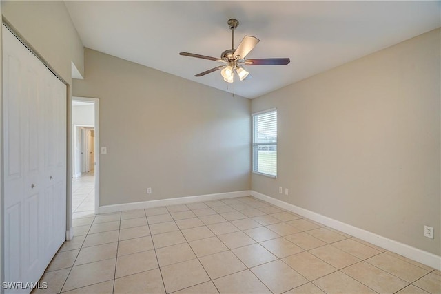 spare room with light tile patterned flooring, ceiling fan, and lofted ceiling