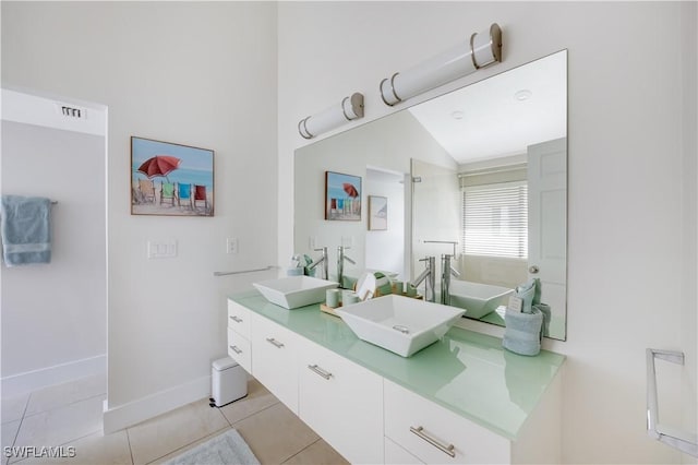 bathroom featuring lofted ceiling, vanity, tile patterned flooring, and a bathtub