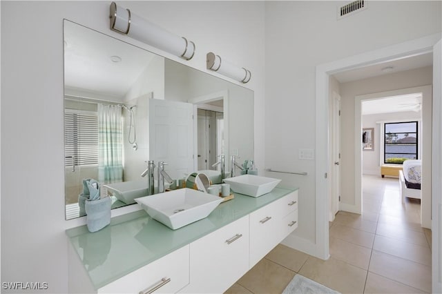 bathroom featuring walk in shower, vanity, and tile patterned flooring