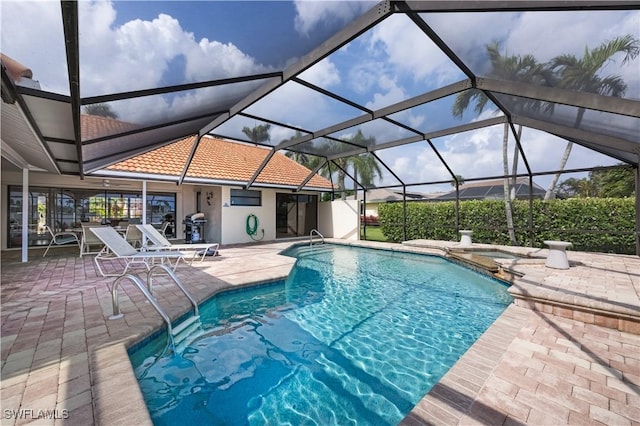 view of swimming pool featuring area for grilling, a lanai, and a patio area