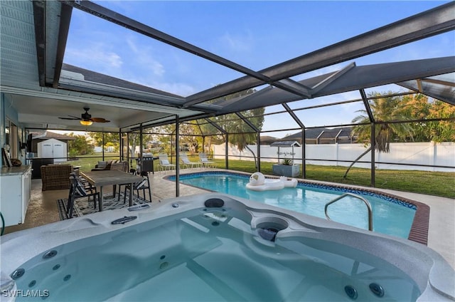 view of pool with a patio, a lawn, glass enclosure, and a shed