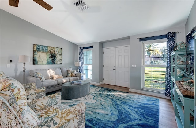 living room featuring lofted ceiling, plenty of natural light, and hardwood / wood-style floors