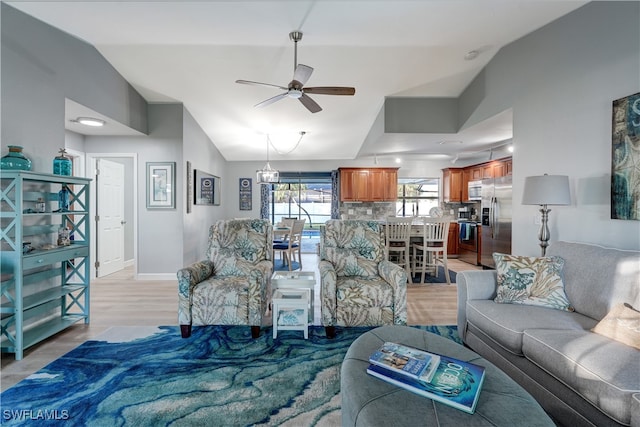 living room with ceiling fan, lofted ceiling, and light wood-type flooring