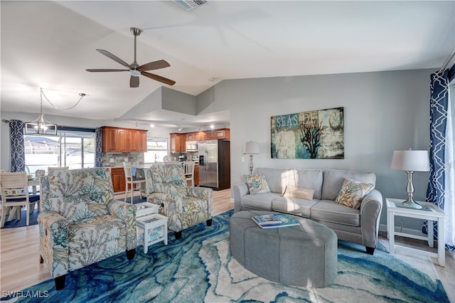 living room featuring vaulted ceiling, light hardwood / wood-style floors, and ceiling fan