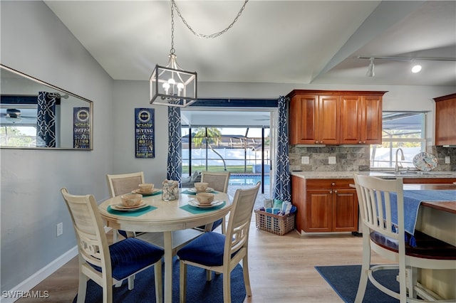 dining space featuring sink, a chandelier, and light wood-type flooring