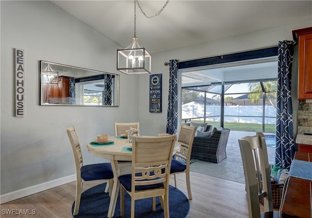 dining space with vaulted ceiling and light hardwood / wood-style floors