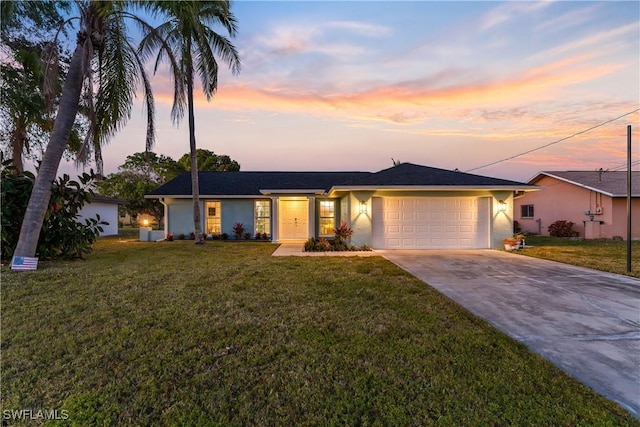 ranch-style house featuring a garage and a yard