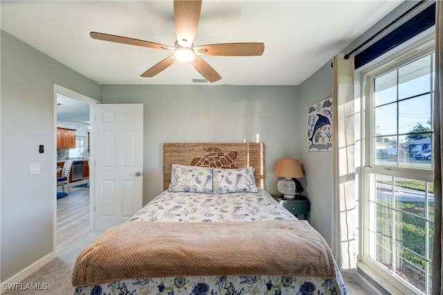 carpeted bedroom with multiple windows and ceiling fan