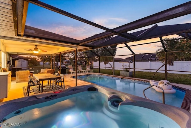 pool at dusk featuring a lanai, a jacuzzi, and a patio