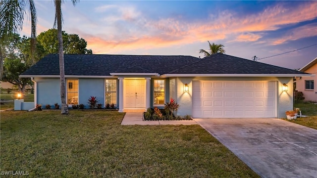 single story home featuring a yard and a garage