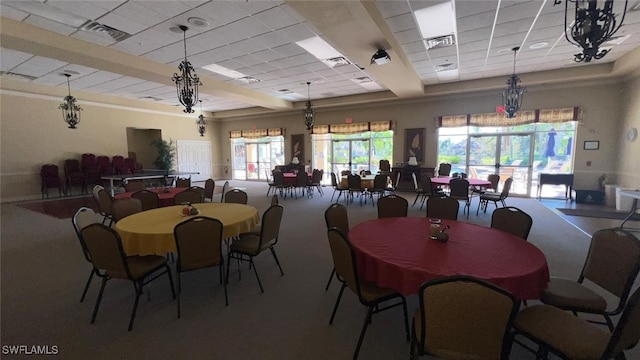 carpeted dining space featuring a drop ceiling and a tray ceiling