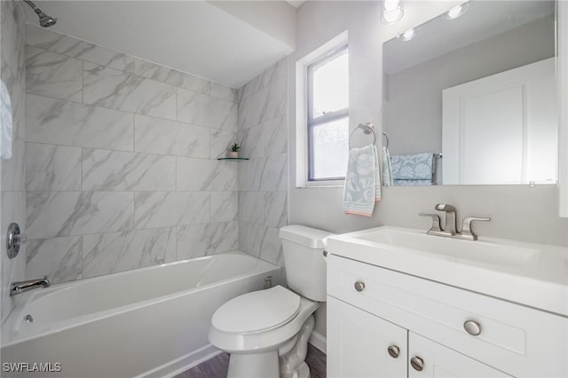 full bathroom featuring tiled shower / bath, vanity, and toilet