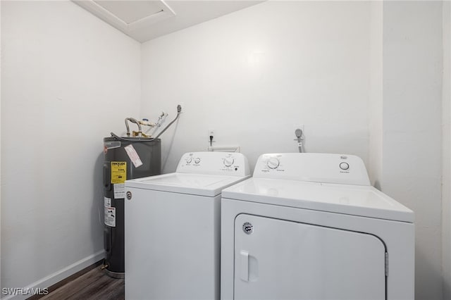 clothes washing area featuring washing machine and dryer, electric water heater, and dark wood-type flooring