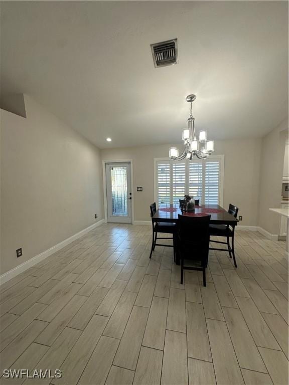 dining room with light hardwood / wood-style flooring and a notable chandelier