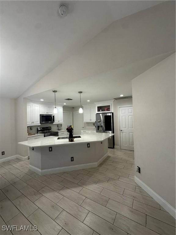 kitchen with stainless steel appliances, white cabinetry, and a spacious island