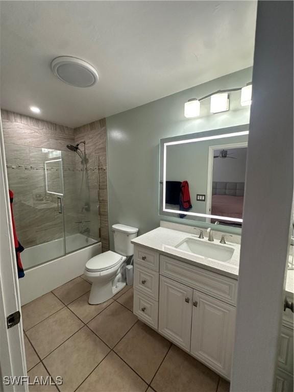 full bathroom featuring vanity, tile patterned flooring, enclosed tub / shower combo, and toilet