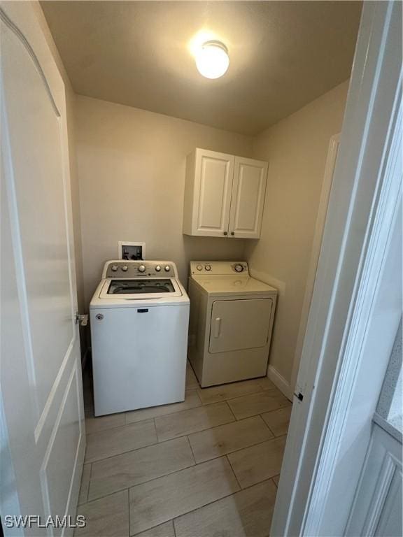 washroom featuring washer and clothes dryer and cabinets