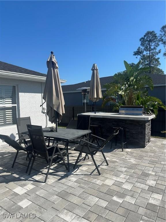 view of patio / terrace with exterior kitchen and an outdoor bar