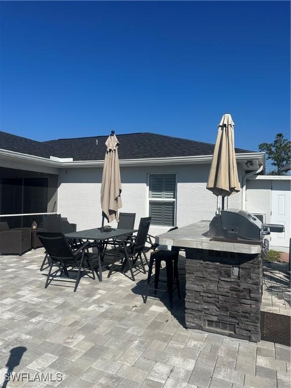 view of patio with area for grilling and an outdoor bar