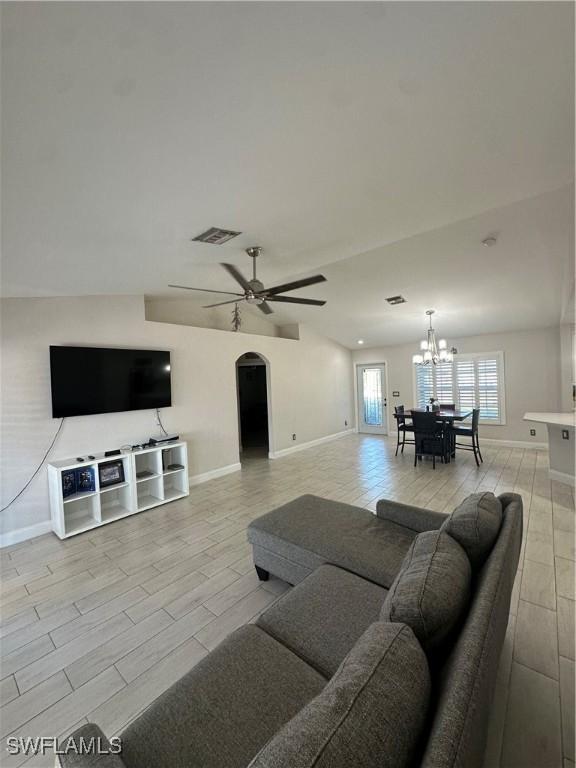 living room featuring ceiling fan with notable chandelier