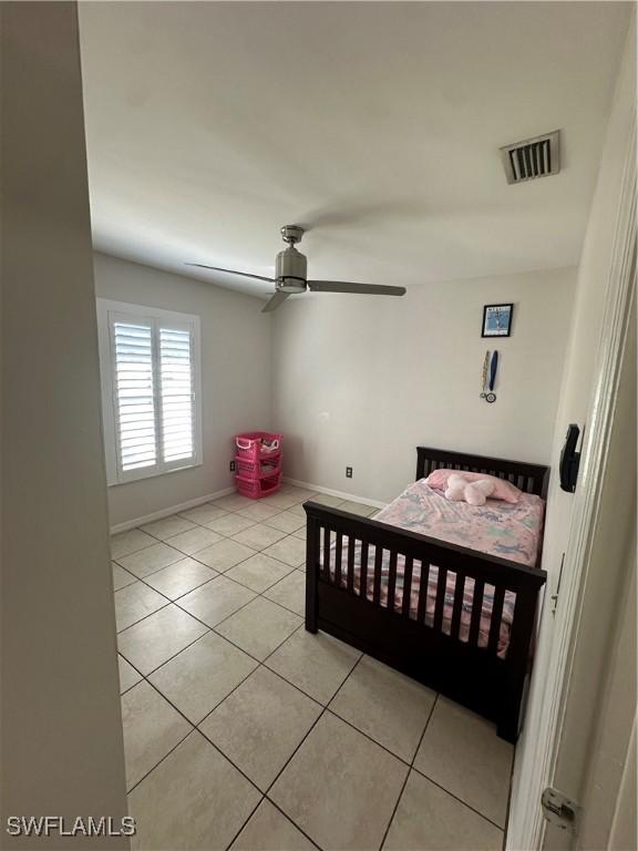 tiled bedroom with ceiling fan