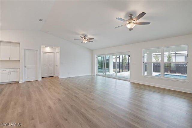 unfurnished living room with vaulted ceiling, ceiling fan, and light wood-type flooring