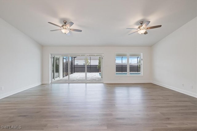 empty room with hardwood / wood-style flooring, vaulted ceiling, and ceiling fan