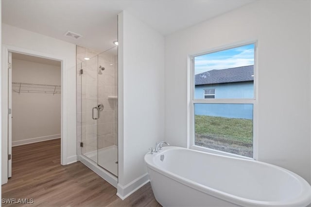 bathroom with hardwood / wood-style floors and separate shower and tub