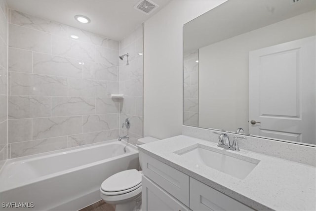 full bathroom featuring vanity, toilet, and tiled shower / bath