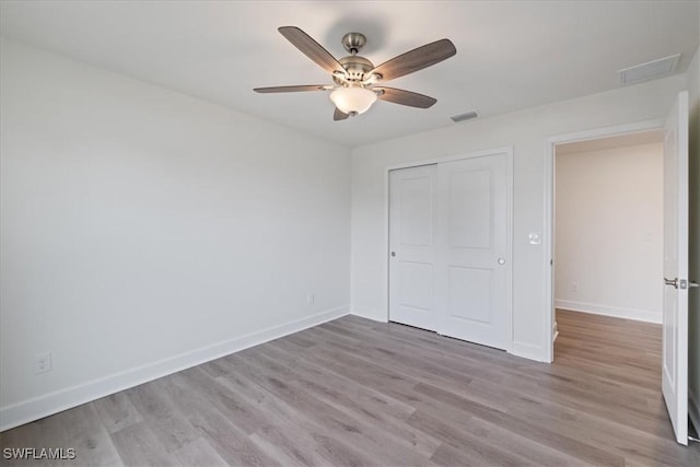 unfurnished bedroom featuring a closet, ceiling fan, and light wood-type flooring