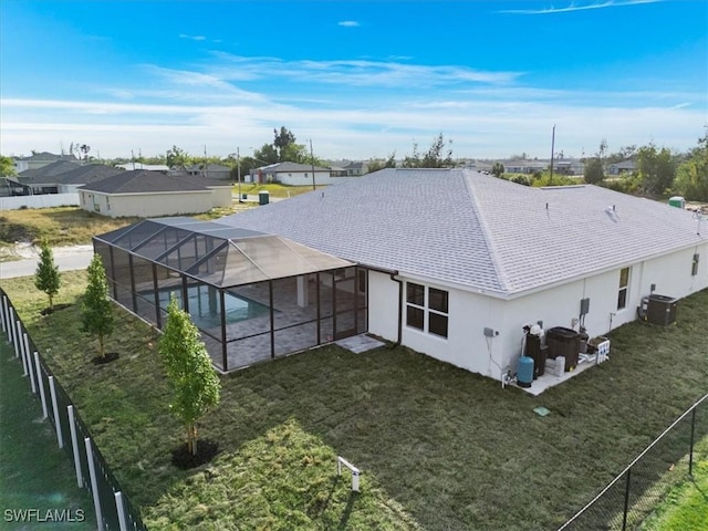 back of property with a yard, a lanai, a patio, and central air condition unit